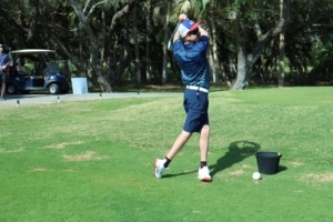 A male golfer swings a golf club in the STARS of the Spectrum Golf program (Flutie Foundation for Autism).